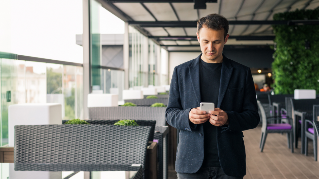 rytel business text messaging man looking down at a cellphone next to seating